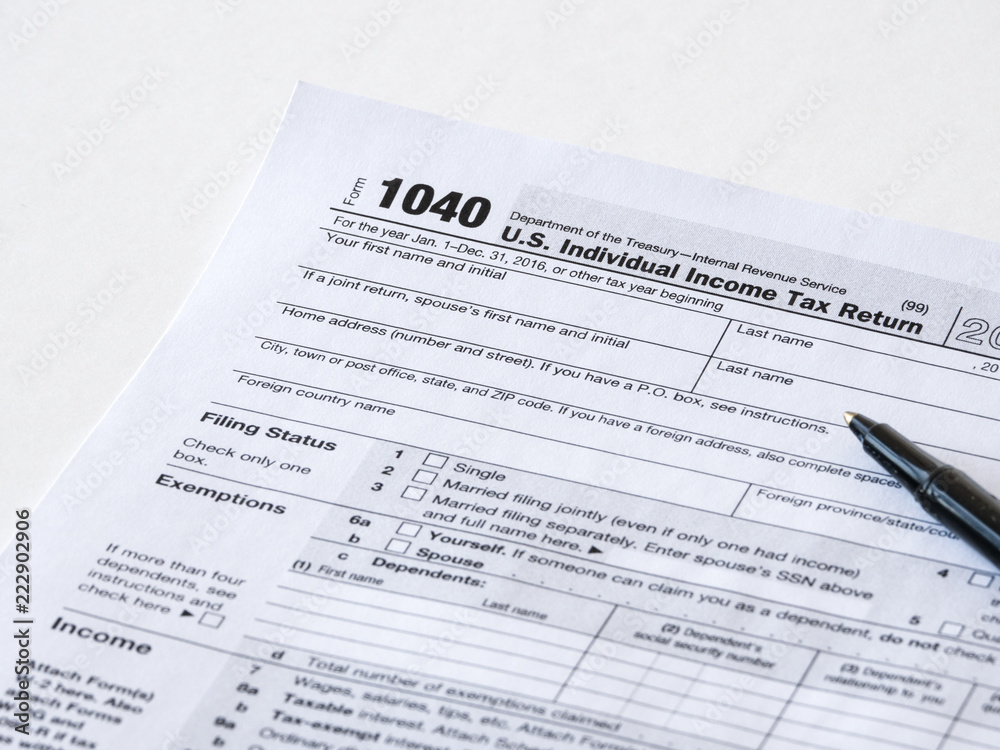 Close up photograph of United States 1040 individual income tax return form with a black ballpoint pen perfect for tax day or tax season background or wallpaper image. Close up photograph of United States 1040 individual income tax return form with a black ballpoint pen perfect for tax day or tax season background or wallpaper image.