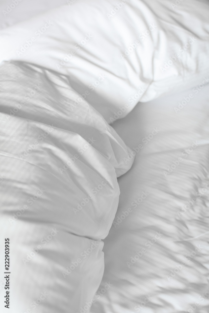 Obraz premium close up bed with crumpled bed sheet, blanket and pillows after comfort duvet sleep waking up in the morning