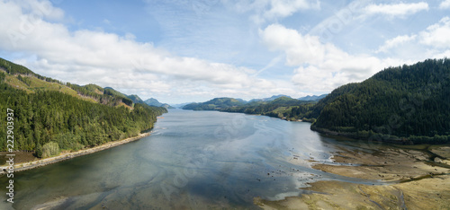 Aerial panoramic landscape view of an Ocean Inlet surrounded by mountains during a vibrant sunny summer day. Taken near Holberg, Northern Vancouver Island, BC, Canada. photo