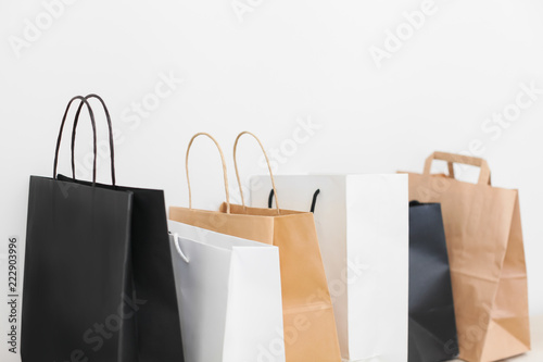 Several shopping bags standing in row on white background
