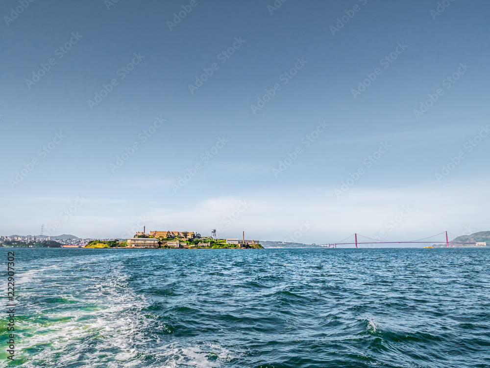 Alcatraz Island with the city of San Francisco and the Golden Gate Bridge in the background across the water beyond.