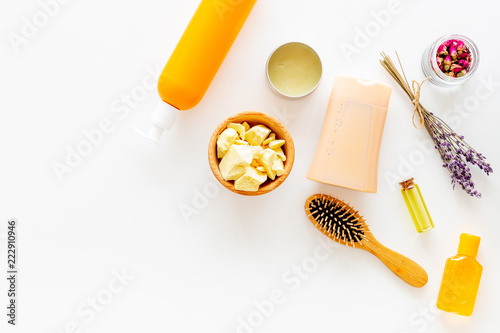 Cosmetics for hair care with jojoba, argan or coconut oil. Bottles and pieces of oil on white background top view copy space