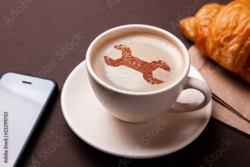 Cup of coffee with  wrench on the foam. I like a coffee break with  croissant. Repair service concept. support
