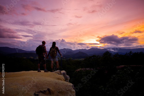 Silhouettes of two hikers with backpacks walking at sunset. Trekking and enjoying the sunset view © doidam10