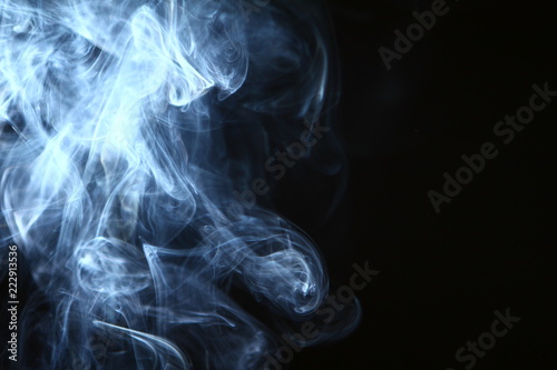 marvellous swirl glowing blue smoke on dark background.