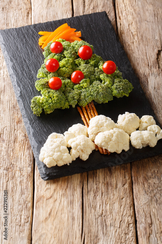 Wallpaper Mural Christmas tree made of fresh vegetables broccoli, cauliflower, tomatoes, peppers close-up on the table. vertical Torontodigital.ca