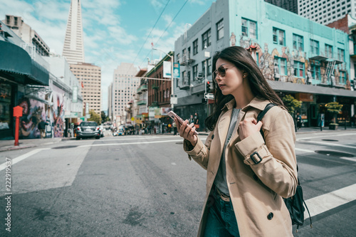 Photography woman using cell phone while crossing the road