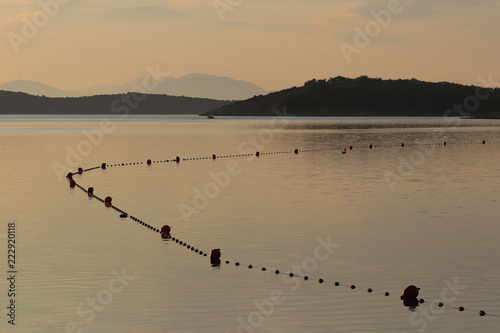 The sea water area is intended for bathing holidaymakers fenced with buoys for safety. Rest on the water in the early morning. Sun rays during the holidays. Arrangement of beaches and reservoirs in to