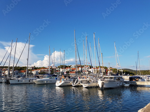 Panorama of a yacht marina in the town of Jezera in Croatia in the Dalmatia region. The ships moored in the port of a quiet fishing town in a sunny, clear day. Tourist marine business. Rest by sea © Xato Lux