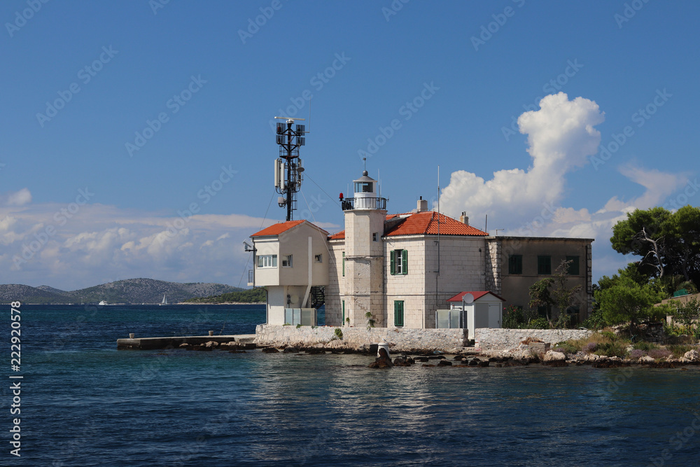 Europe. Adriatic seaof Mediterranean area. Dalmatian region. Croatia.  Outpost of a maritime port with a beacon near Sibenik city. Duty station of the Marine Police in sunny day.