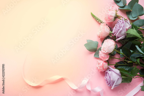 Frame of purple and pink roses, white Lisianthus and different flowers on pink background.