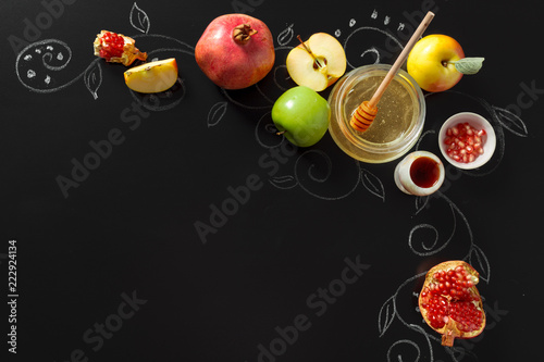 Pomegranate, apple and Honey for traditional holiday symbols Rosh hashanah (jewish new year holiday) on black background photo
