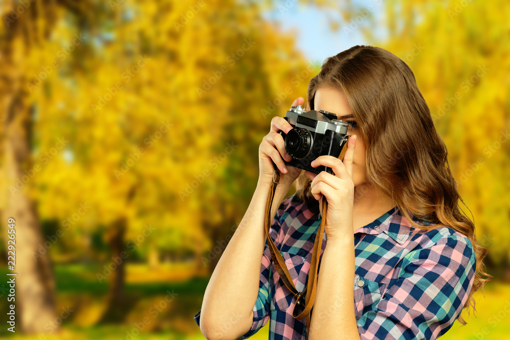 Young pretty girl with camera in autumn park