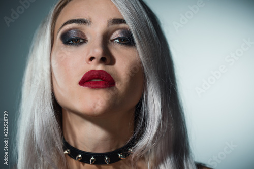 фотографія Portrait of a beautiful blonde with red lips  a collar with spikes