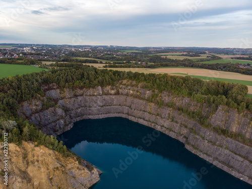 (Luftaufnahme, Drohne) Panorama mit blauem Kratersee im Steinbruch im Vordergrund