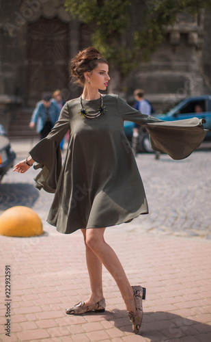 The young elegant, stylish woman standing on the street