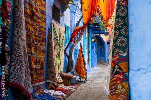 Traditional carpets in colorful narrow street of Chefchaouen in Morocco © Marko Rupena