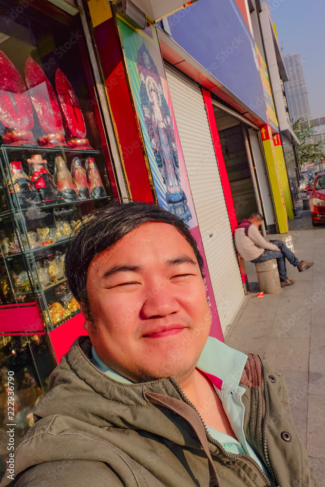 Obraz premium selfie Photo of Asian fat man traveler on the street in yiwu city china
