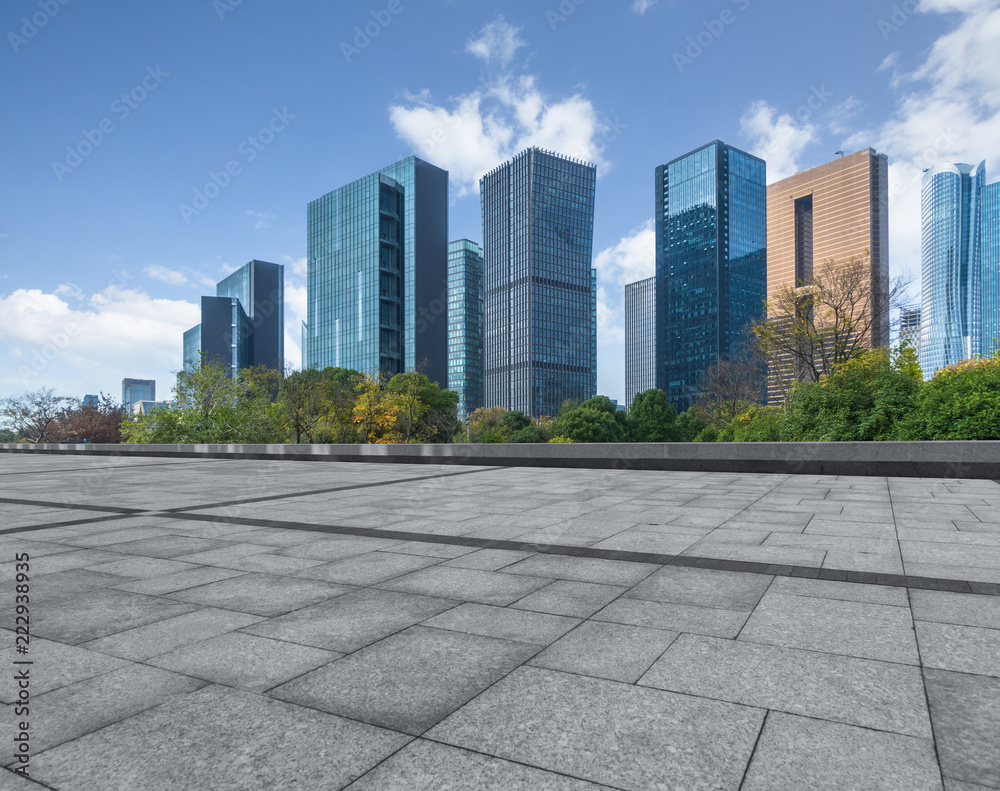 empty pavement and modern buildings in city.