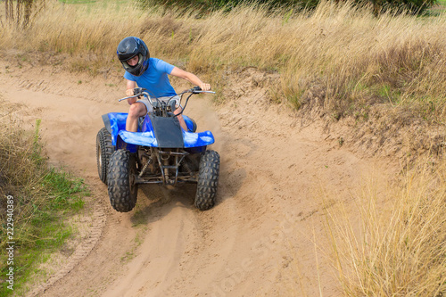 Young man driving quad through curve