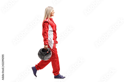 Female racer walking and holding a helmet