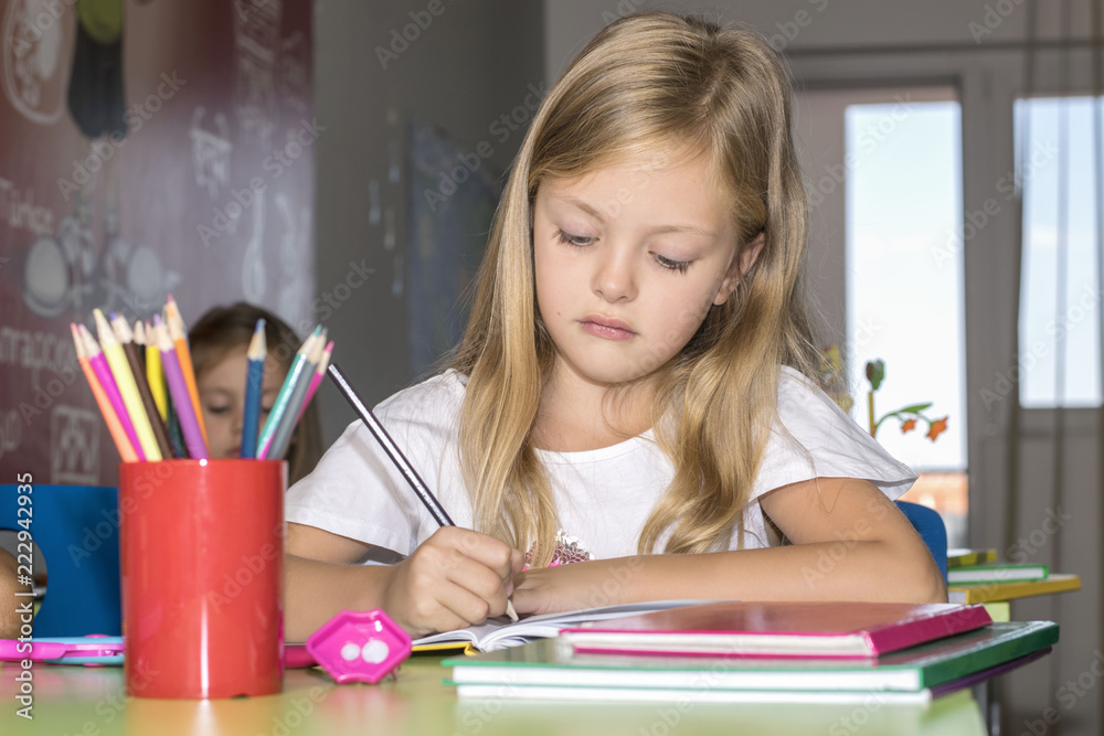 School children are sitting in the classroom and writing School children are sitting in the classroom and writing