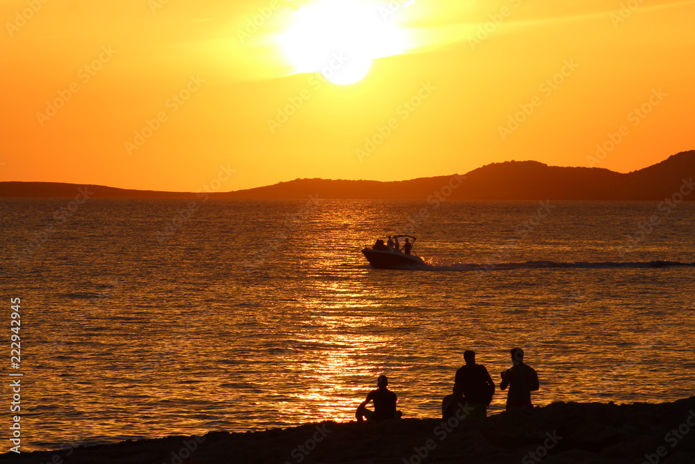 Ibiza sunset with boat and people silhouettes: golden light Ibiza sunset with boat and people silhouettes: golden light