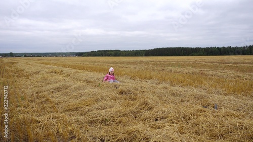 Child, girl 4-5 years old, playing in the field. Mowing grass, hay, autumn landscape