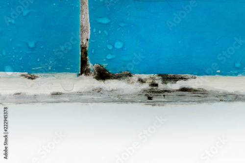 dirty bathroom with mold and water drops on blue tile closeup with details
