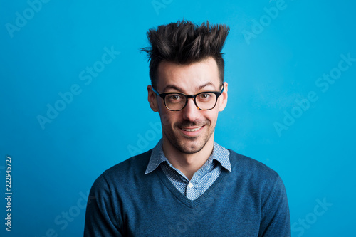 Portrait of a young man in a studio with spiky hairstyle.