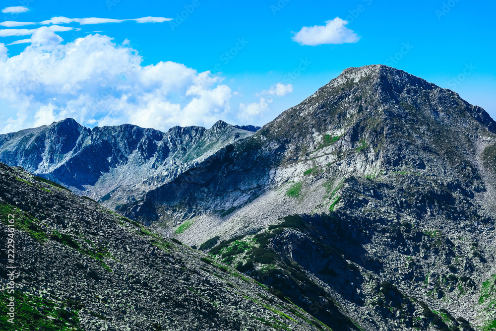 Beautiful alpine high mountains peaks, blue sky background. Amazing Mountain hiking paradise landscape, summertime.
