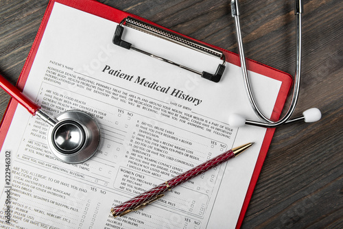 medical history with stethoscope and pen