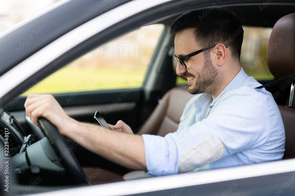Businessman ignoring safety and texting onmobile phone while driving Businessman ignoring safety and texting onmobile phone while driving