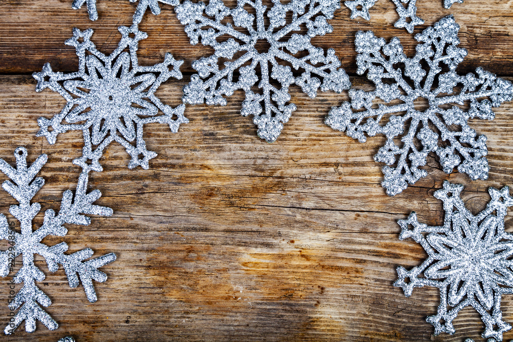 Silvery snowflakes on a wooden background. Silvery snowflakes on a wooden background.