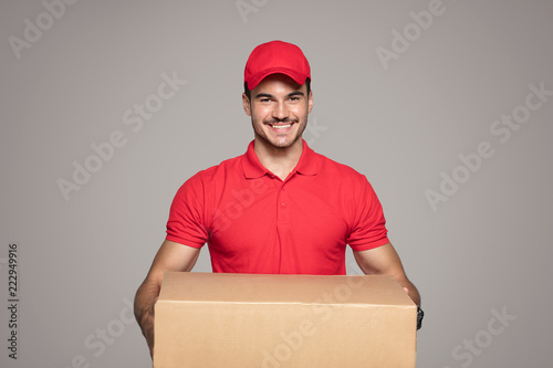 Smiling courier man holding a box package.