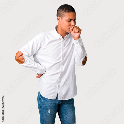 Young african american man is suffering with cough and feeling bad on grey background