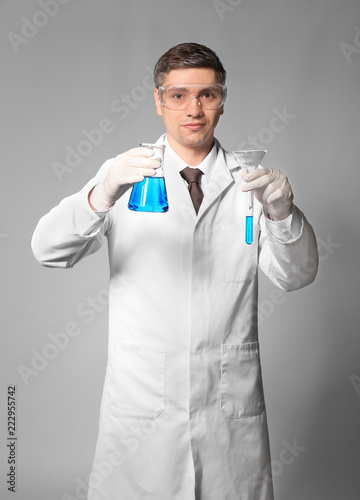 Scientist with test sample on grey background
