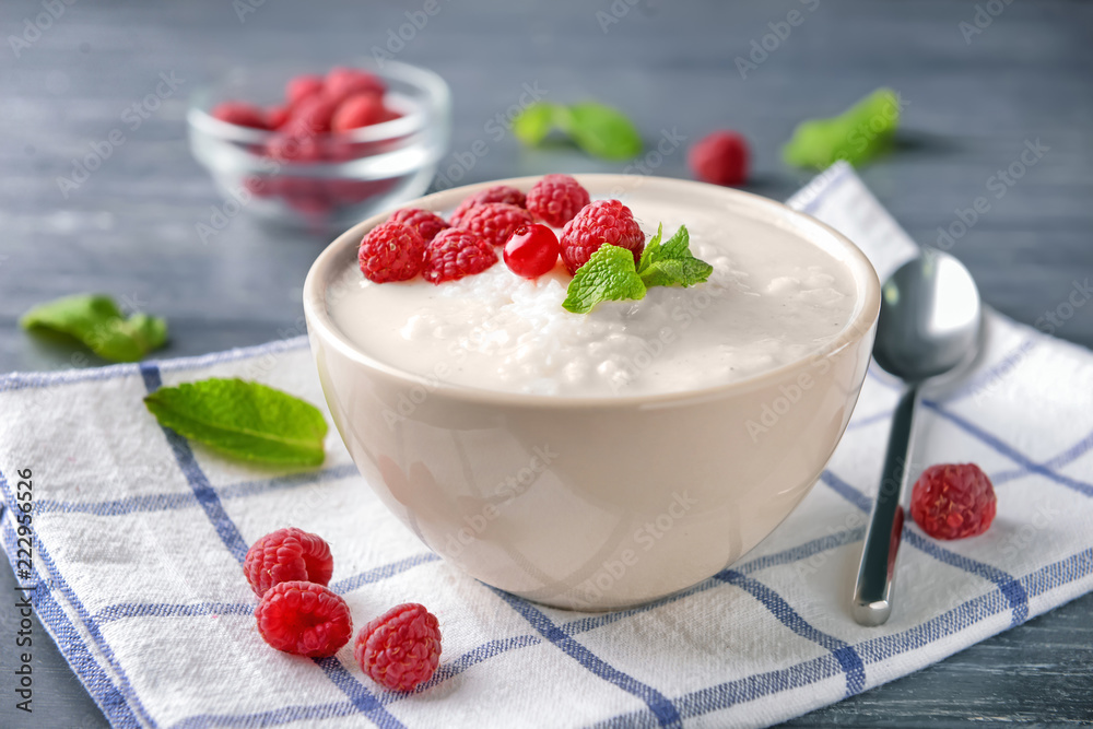 Bowl with delicious rice pudding and berries on napkin Bowl with delicious rice pudding and berries on napkin