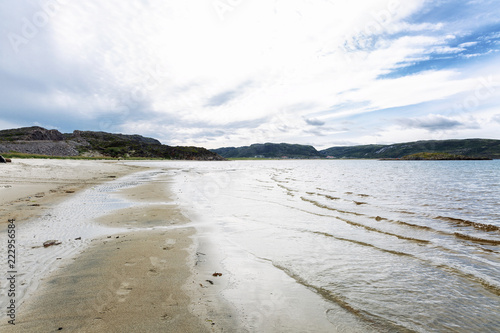 Sandy shore of the northern sea, hills, cloudy sky, beautiful landscape