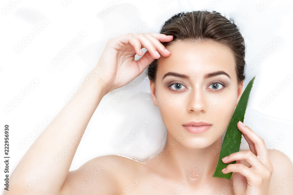 Portrait of young sexy female woman adult with clean pure skin taking spa smiling relaxing in bath with aloe white soap shampoo water. Skin beauty health care concept. Body part bare shoulder Portrait of young sexy female woman adult with clean pure skin taking spa smiling relaxing in bath with aloe white soap shampoo water. Skin beauty health care concept. Body part bare shoulder