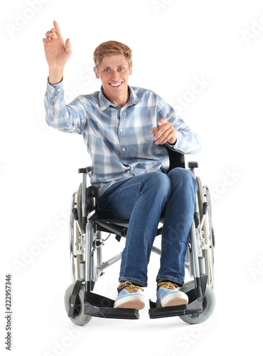 Young man sitting in wheelchair on white background © Pixel-Shot