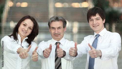 closeup . successful business team holding up a thumbs up