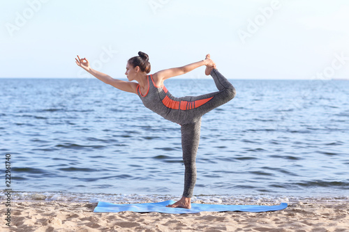 Woman practicing yoga on se...