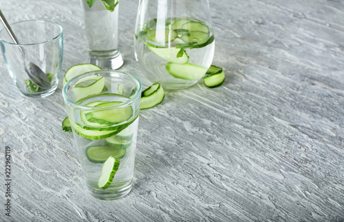 Glass of fresh cucumber water on light table