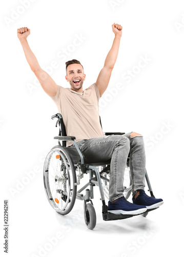 Happy young man sitting in wheelchair on white background