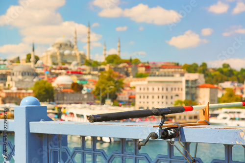 Iconic Istanbul picture. Fishing rod on Galata bridge with Istanbul panorama in the background. Tourism in Turkey. Focus on rod.