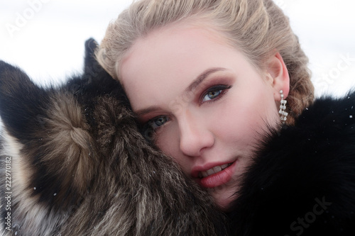 winter, christmas, holiday, sweets, lifestyle and animal concept - Young woman with wolf dog in snow photo