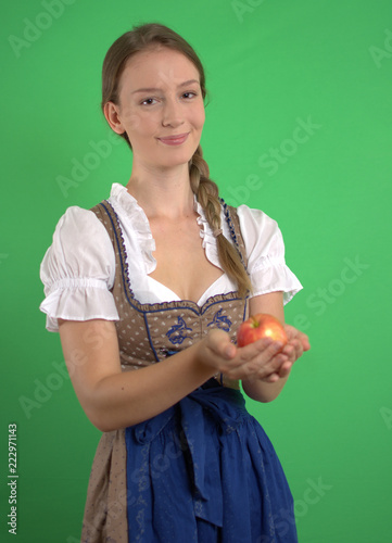 Junge Frau im Dirndl mit Apfel