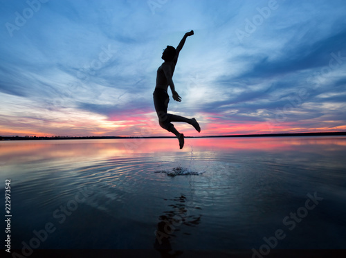 Mann springt hoch aus den Wasser 
