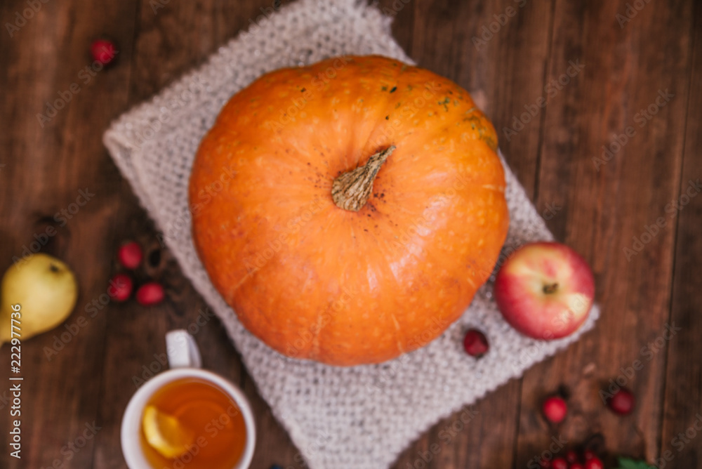 Top view of autumn workplace, pumpkin, tea, apples and book on wooden table. Top view of autumn workplace, pumpkin, tea, apples and book on wooden table.